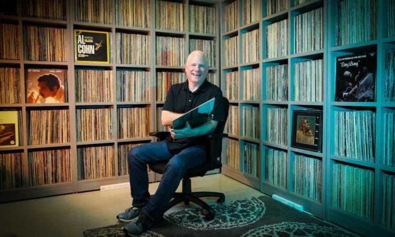 Sam Skelton sits in front of 9,000 vinyls records donated to Kennesaw State University.