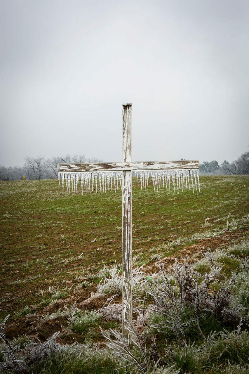 A photo of a wood cross coated in ice in a Georgia field.